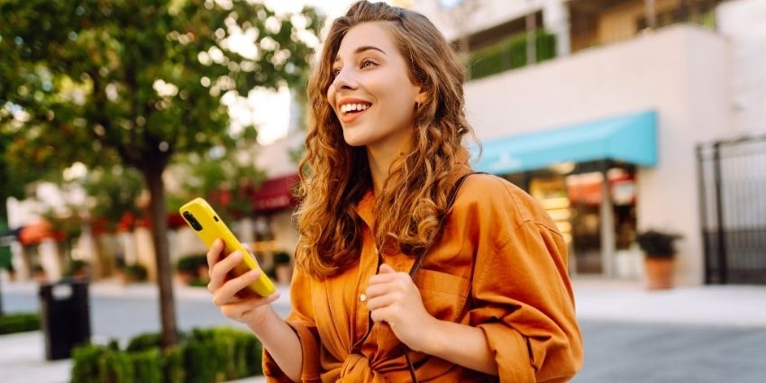 Female holding a phone on a highstreet