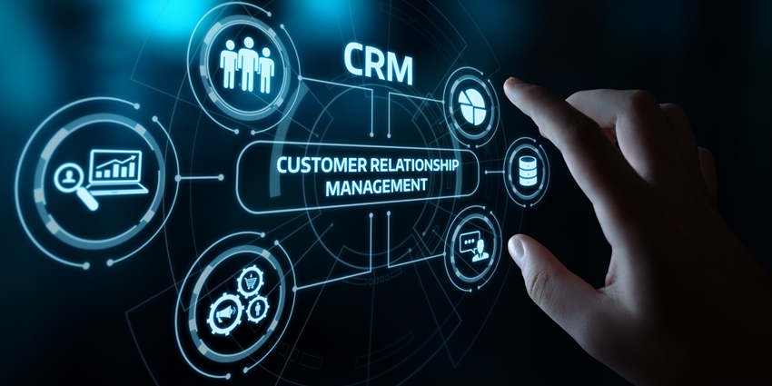 A finger pointing to a dashboard with various icons the central one being customer relationship management