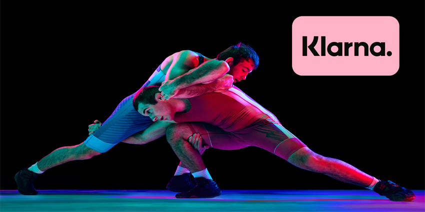 Two young athlete man, skilled wrestlers in red and blue uniform wrestling in motion against black background in mixed neon lights. Concept of motion,