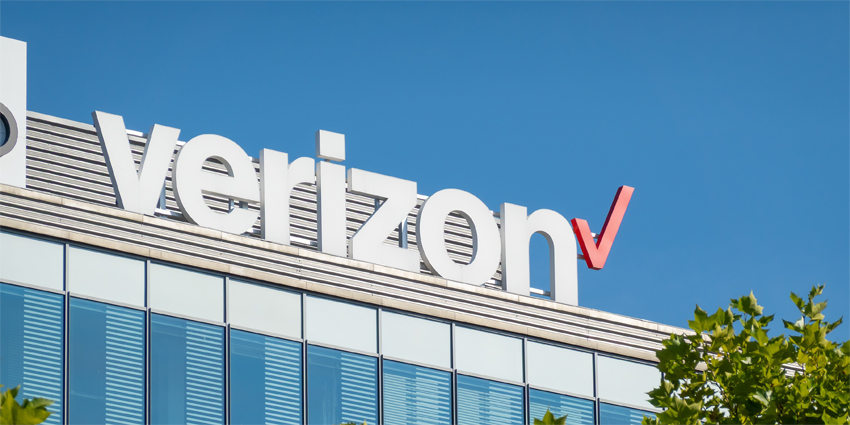 Banner of Verizon mobile carrier on modern building behind trees